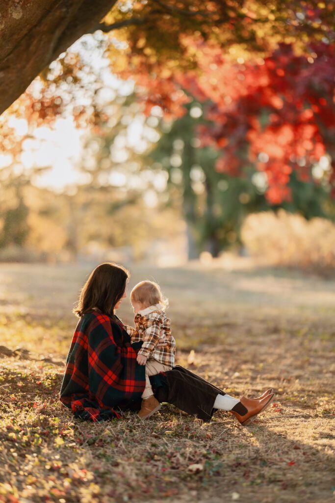 Fall family photo of mother holding toddler on lap