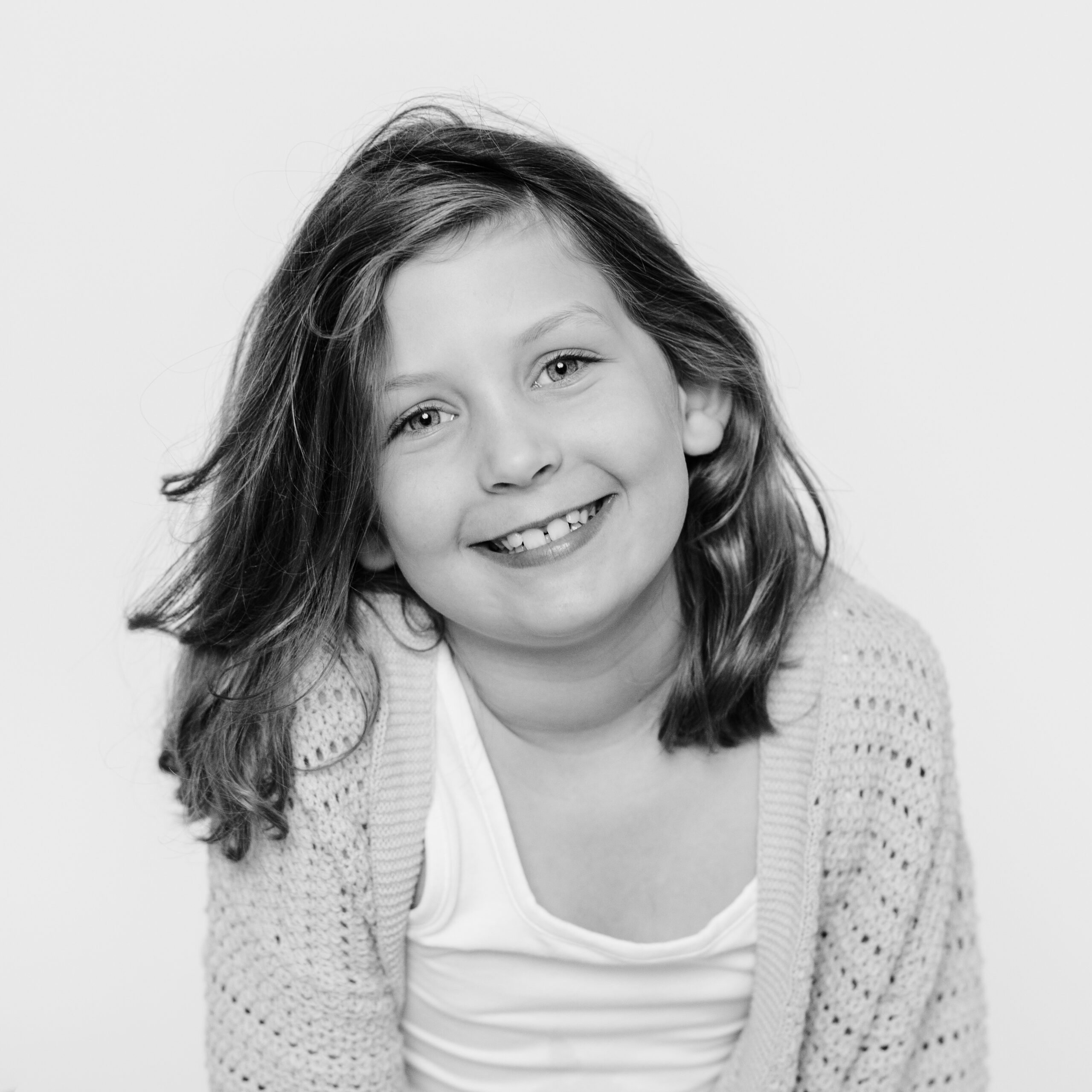 child's personality portrait of girl smiling in knit sweater